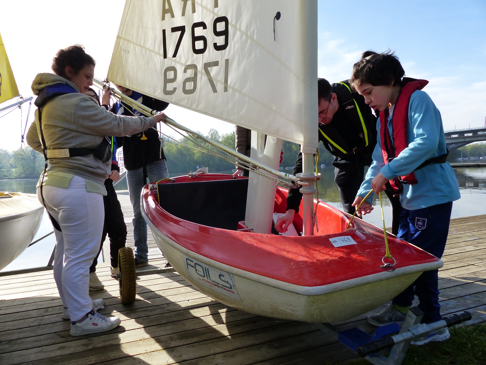 Les jeunes préparent les bateaux sur le ponton avec l'aide de leurs éducateurs