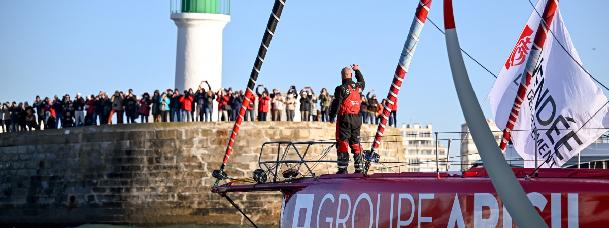 L'IMOCA Groupe Apicil fait son entrée dans le chenal des Sables d'Olonne, accueilli par une foule de spectateurs, à l'arrivée du Vendée Globe 2024-2025.