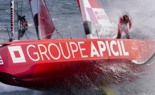 Silhouette lointaine d'un skippeur à bord d'un monocoque de course au large au large volant sur l'océan