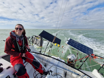 Alix Jaekel avec un grand sourire à la barre du Mini 6.50 Des Pieds et Des Mains