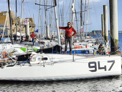 Navigatrice debout à bord d'un monocoque amarré au ponton